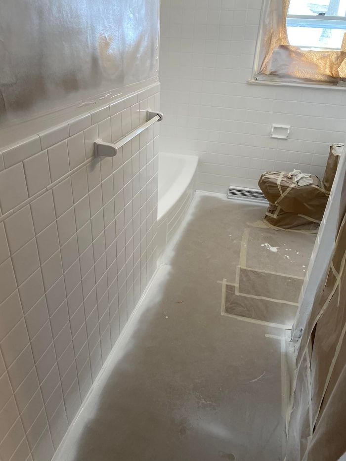 Image of a bathroom taped up as preparation for the bathtub refinishing. 