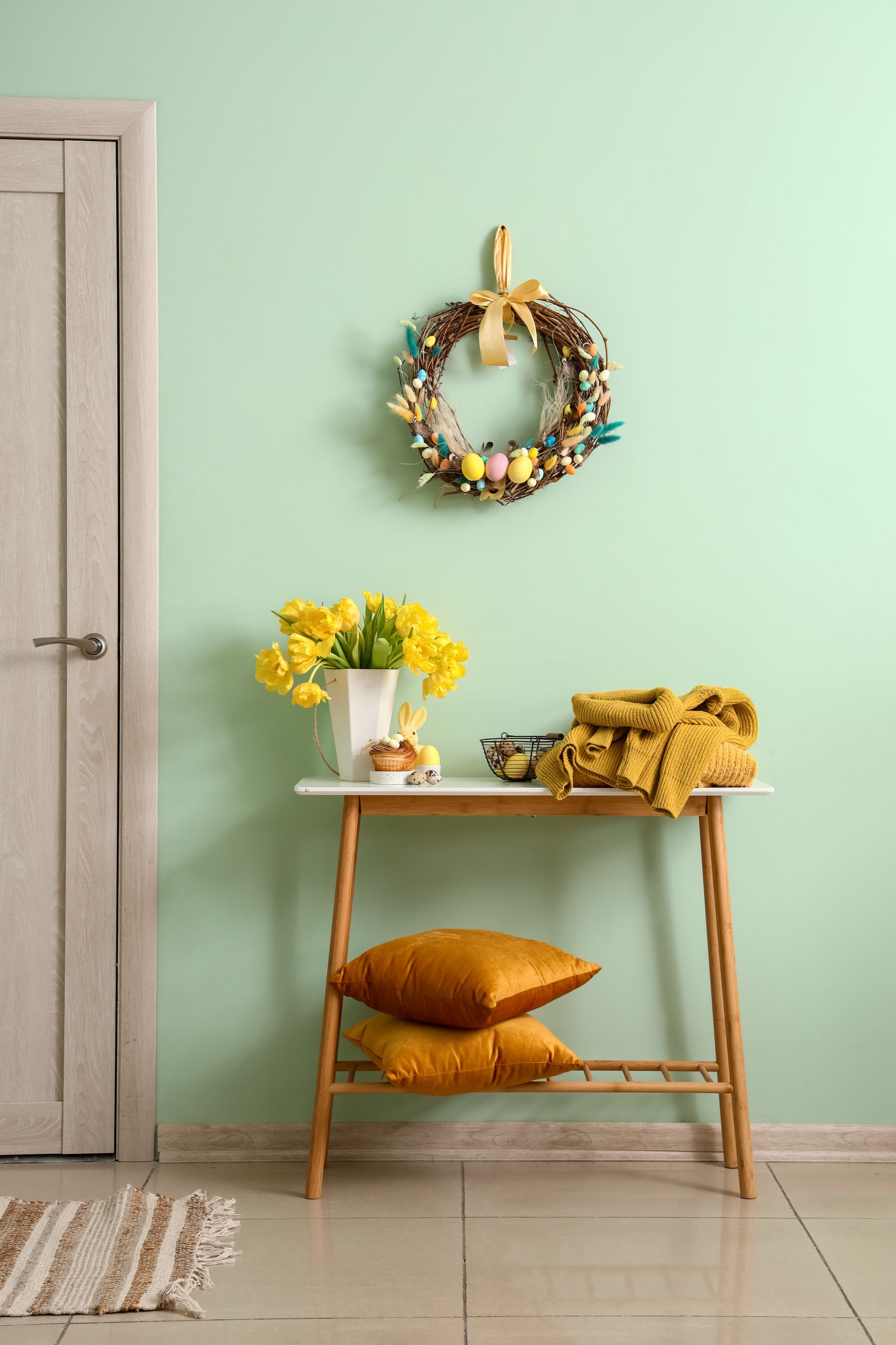 A hallway with a table and a wreath on the wall.