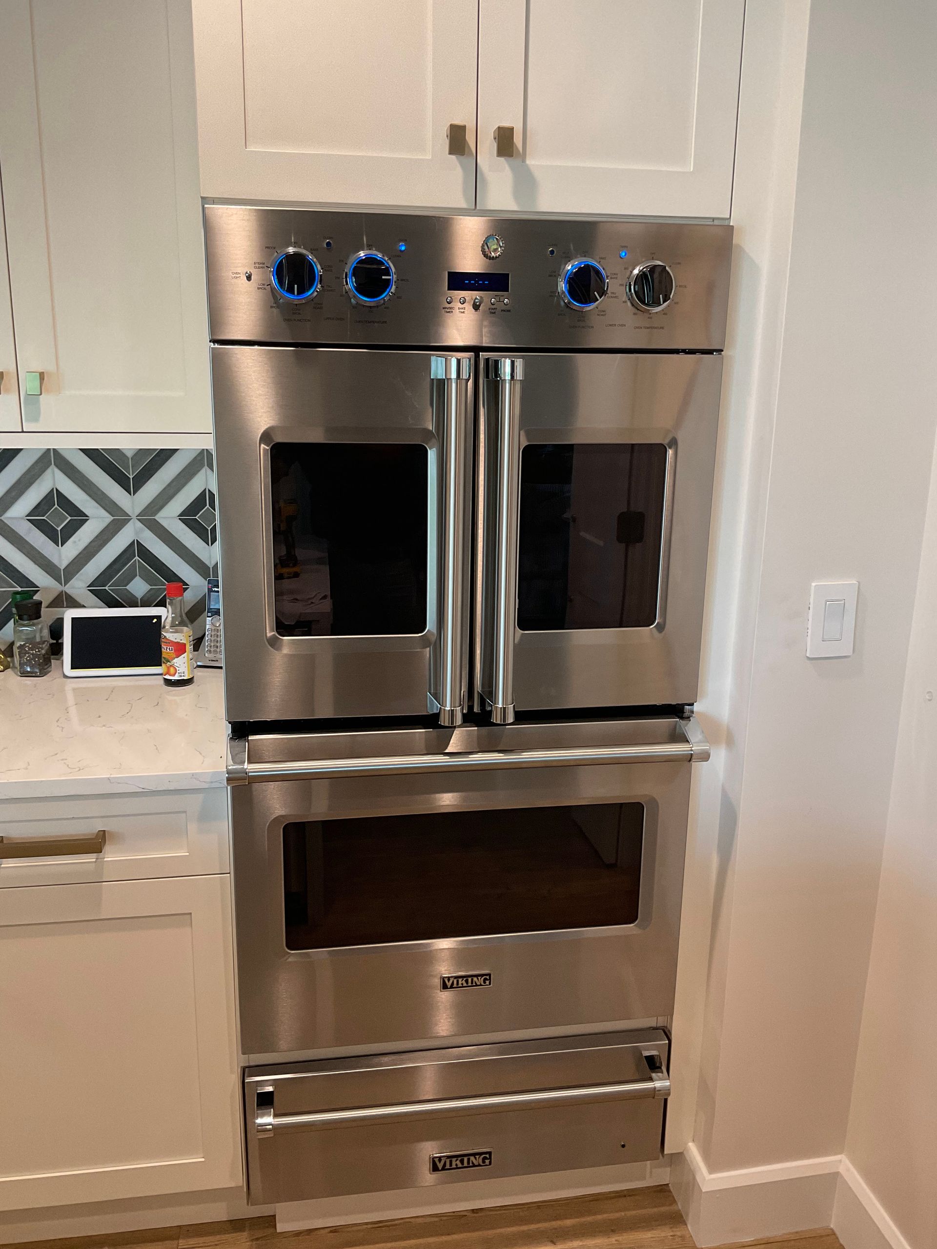 A stainless steel oven is sitting on top of a kitchen counter.