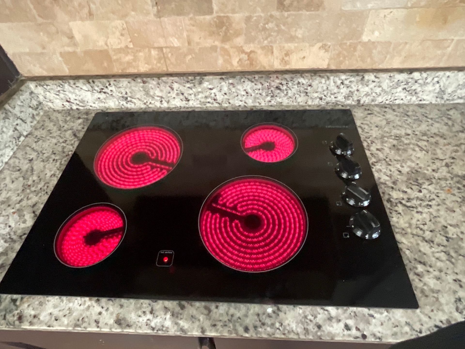 A stove top oven is sitting on top of a granite counter.