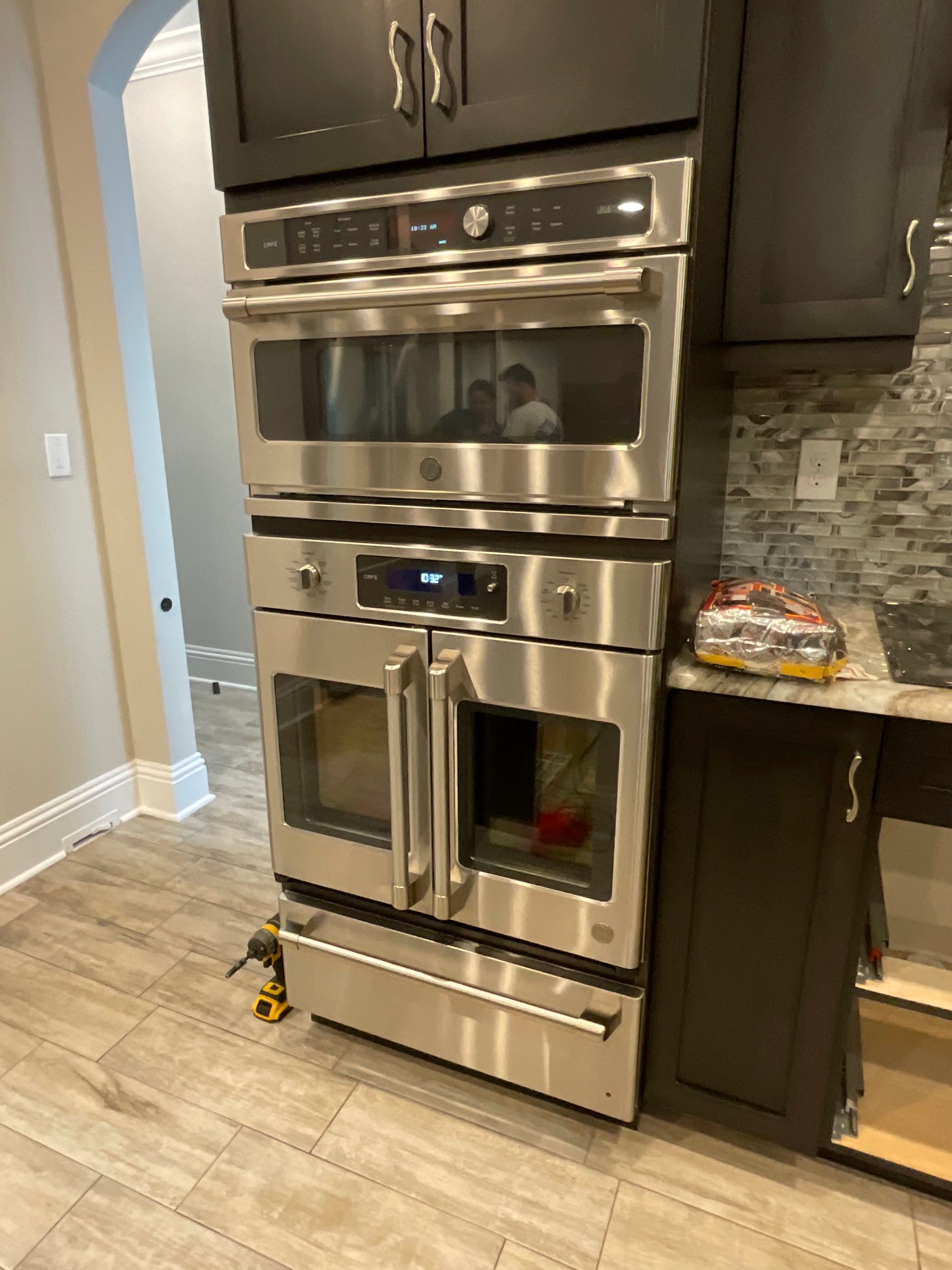 A stainless steel oven and microwave are in a kitchen.