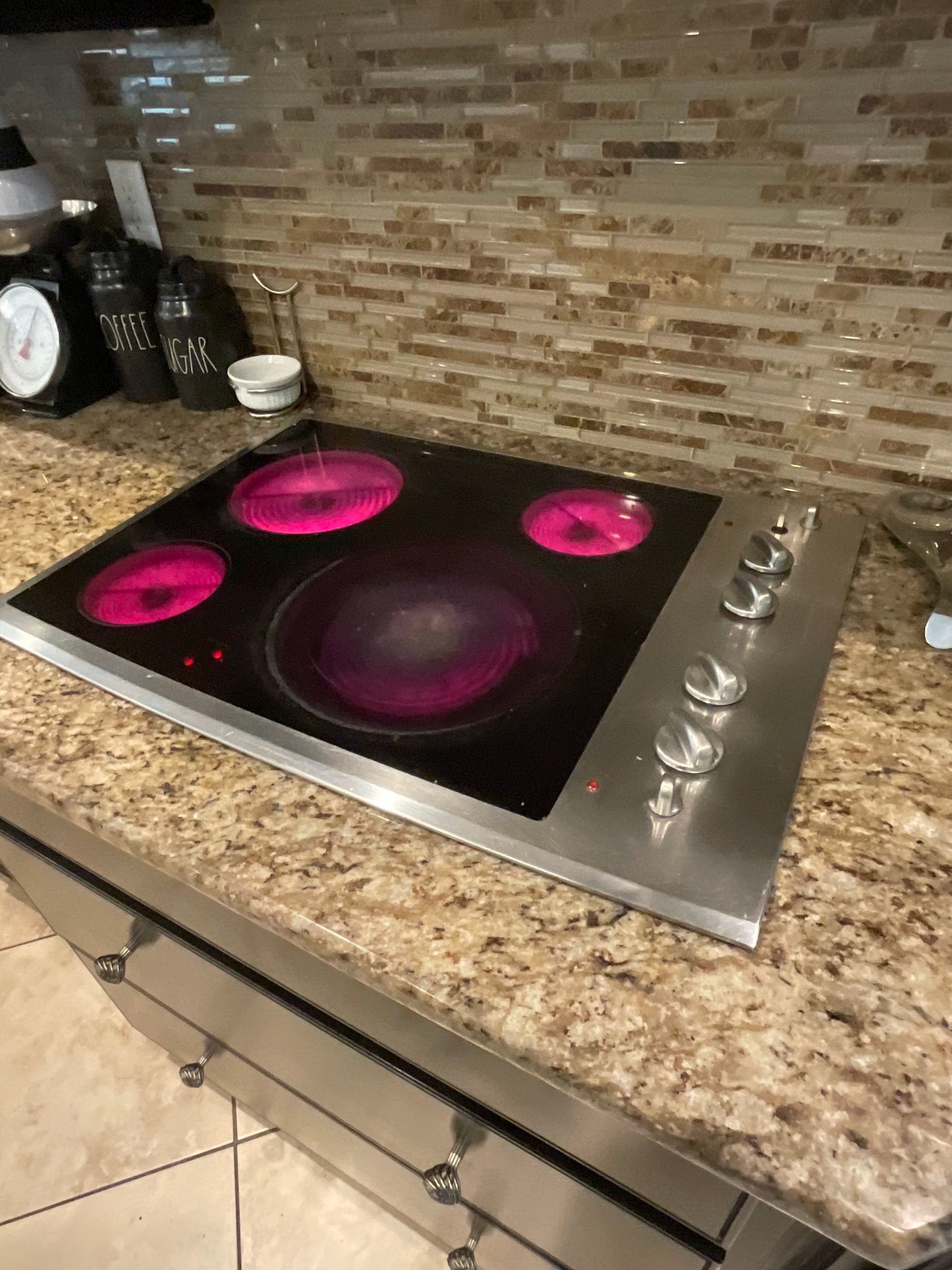 A stove top oven is sitting on top of a granite counter top.