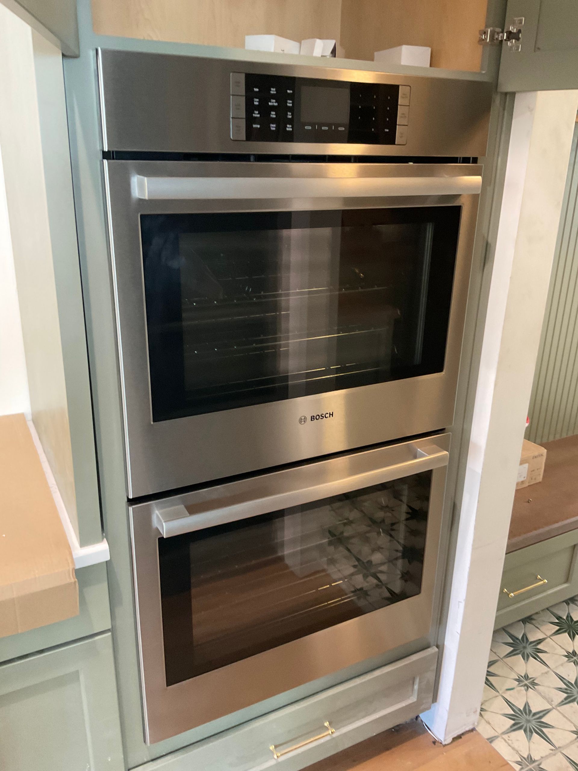 A stainless steel double oven is sitting in a kitchen.