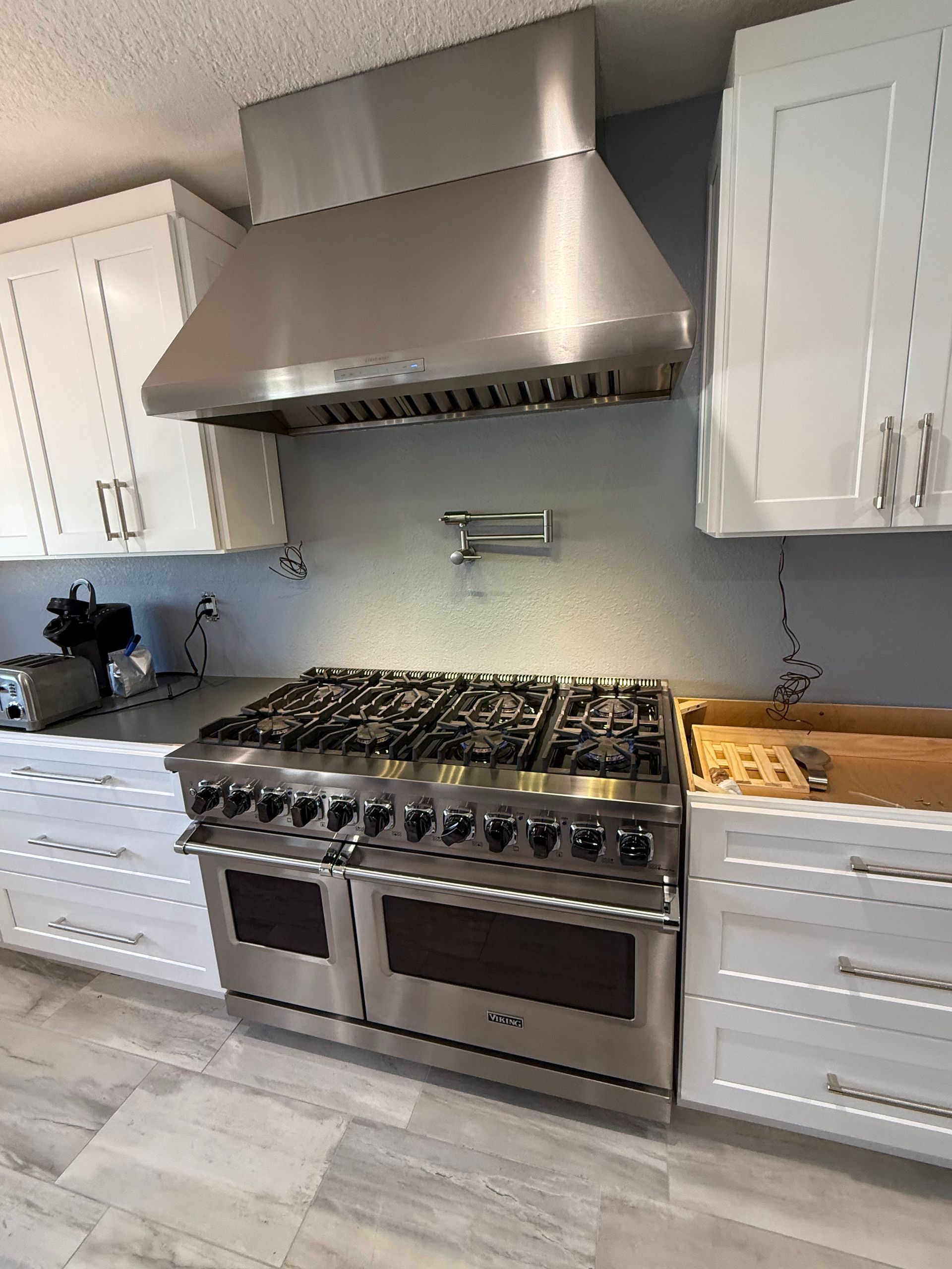 A kitchen with stainless steel appliances and white cabinets.