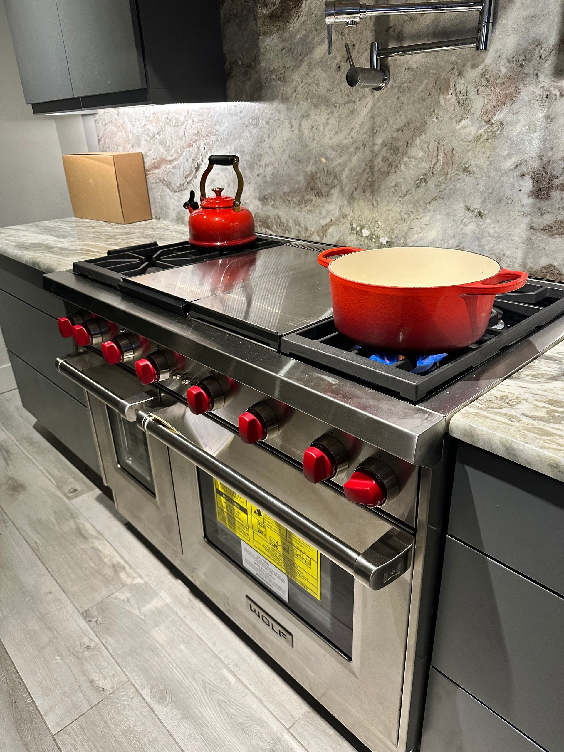 A pot is cooking on a stove in a kitchen.