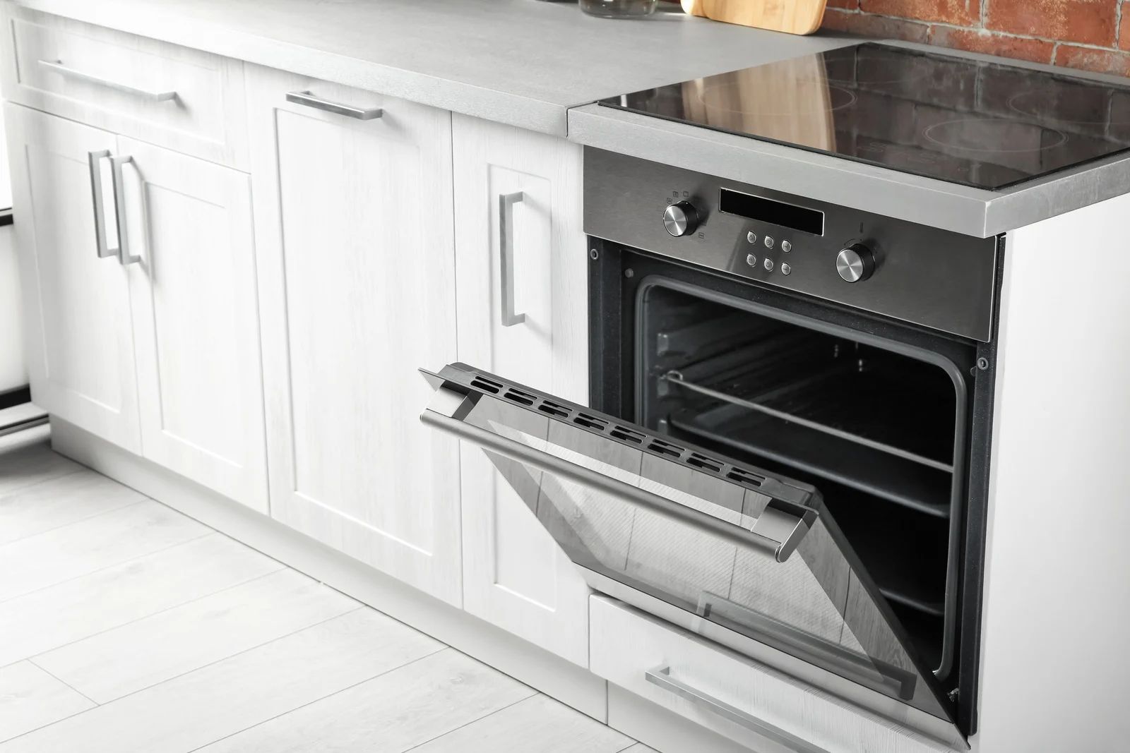 White kitchen with open oven.