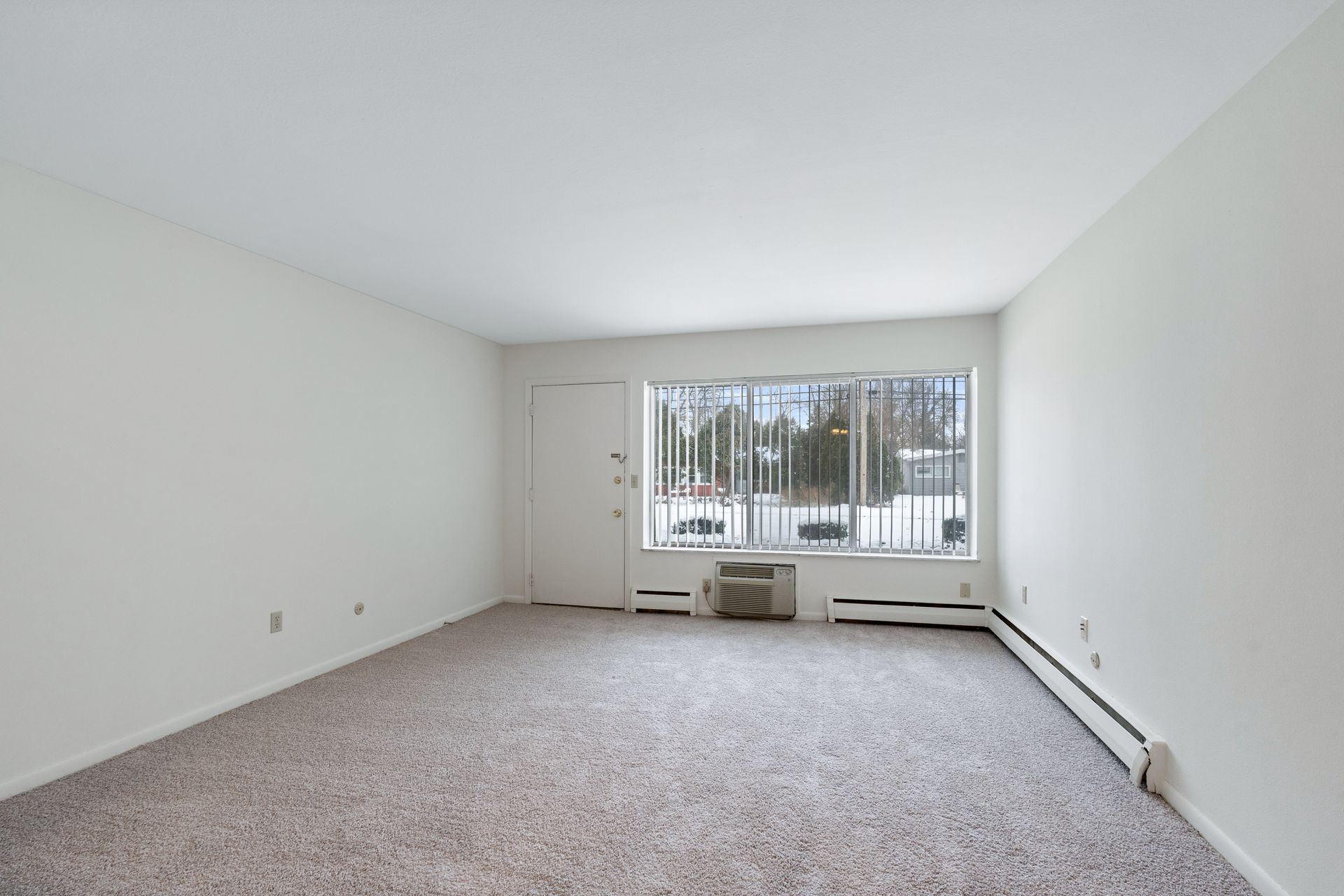 Photo of the living room, with a wide window at the front of the room