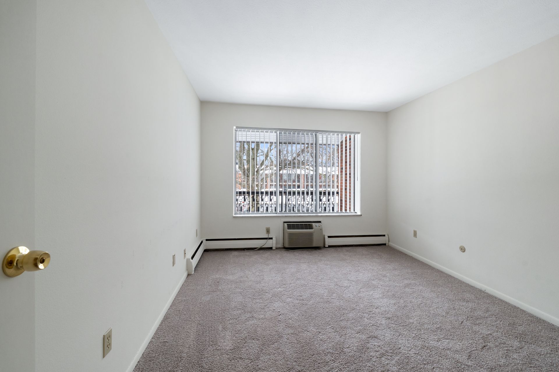 Photo of a bedroom, showing the door at the left of the photo