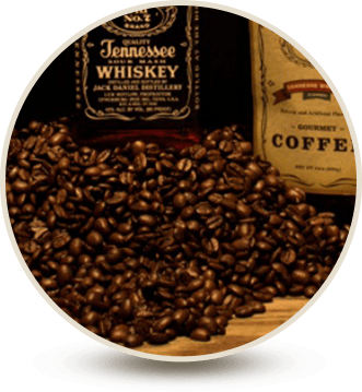 close up of coffee beans in front of whiskey bottle
