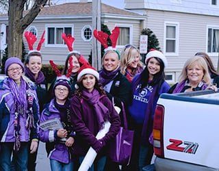Lori Nettles with a group of high schoolers wearing reindeer antlers