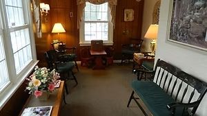 A professional man and woman stand behind a modern white reception desk in a brightly lit dental clinic lobby. A professional man and woman stand behind a modern white reception desk in a brightly lit dental clinic lobby.