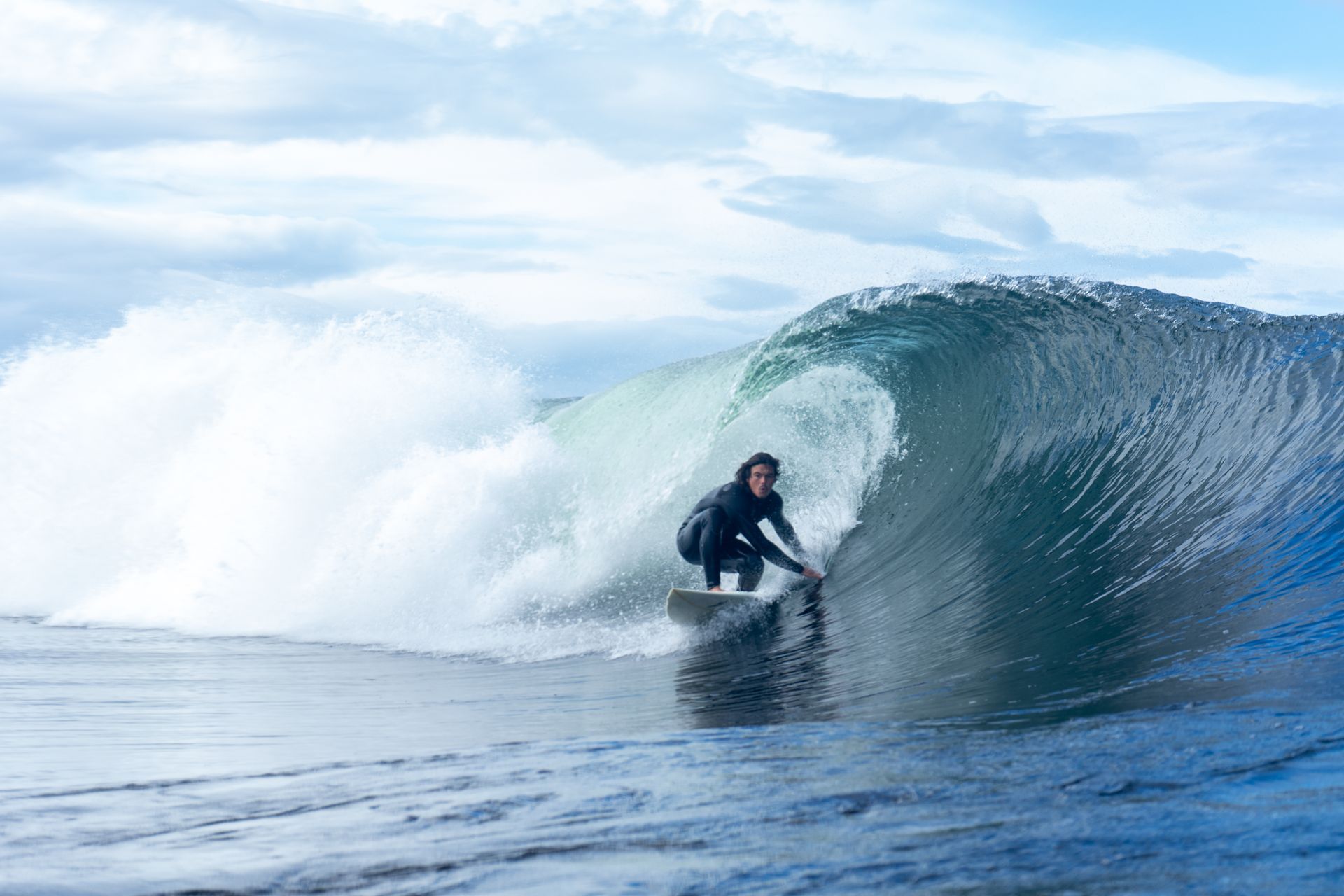 A man is riding a wave on a surfboard in the ocean.