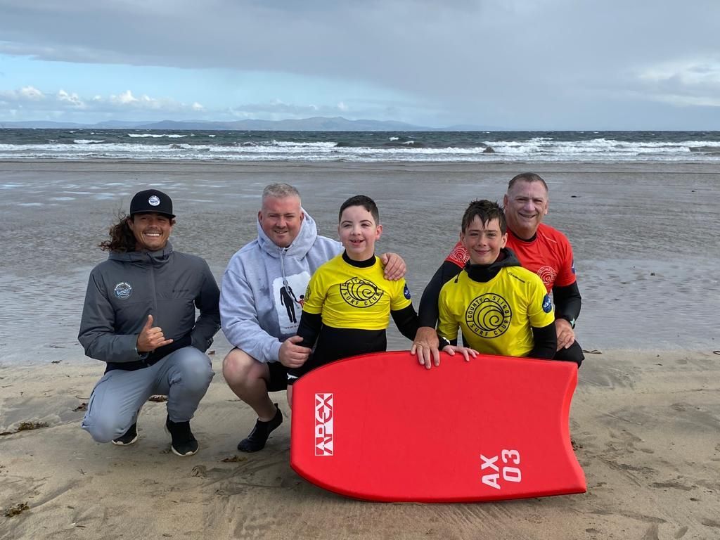 A group of people are posing for a picture on a beach