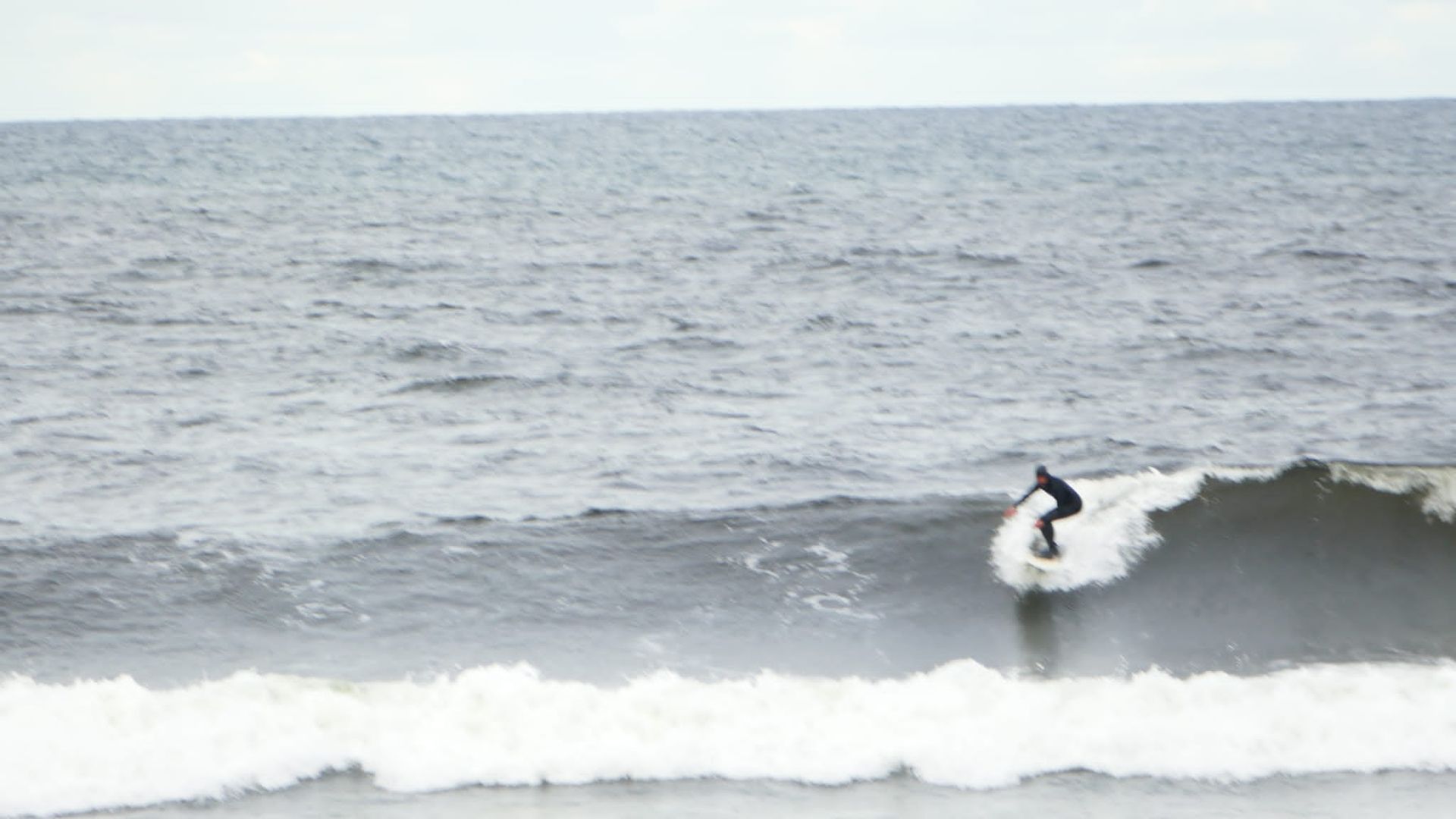 A person is riding a wave on a surfboard in the ocean.