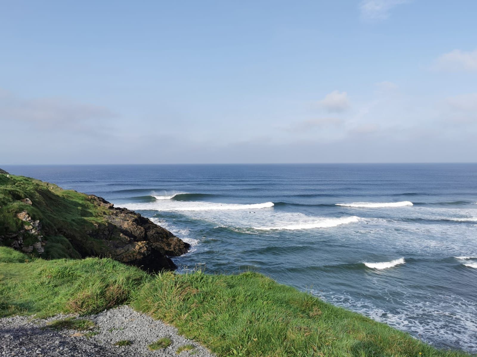 A view of the ocean from a cliff on a sunny day