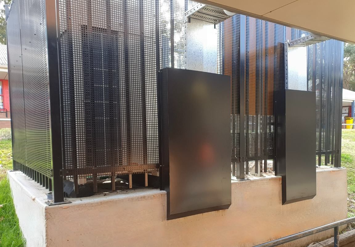 A Black Metal Fence is Surrounding a Building in a Park — Accurate Fitout Solutions In Wetherill Park, NSW