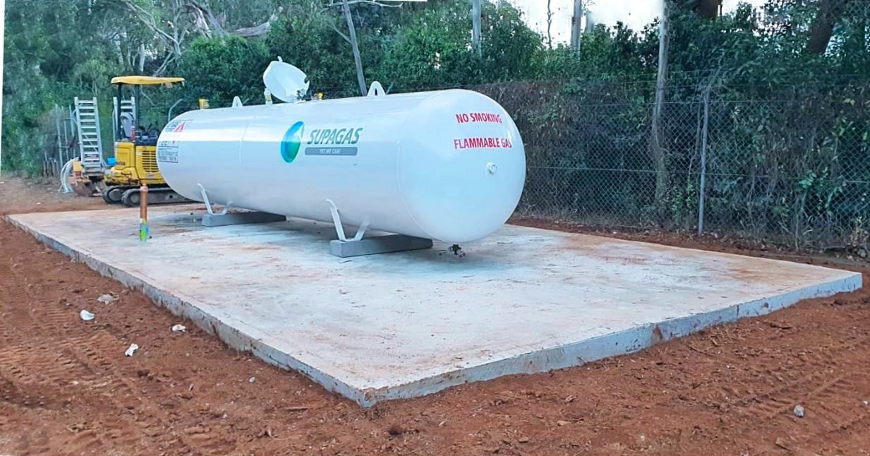 A Large Propane Tank is Sitting on Top of a Concrete Platform — Accurate Fitout Solutions In Alexandria, NSW
