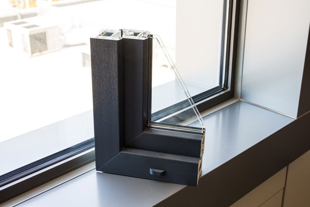 A Black Window Frame is Sitting on a Window Sill — Accurate Fitout Solutions In Wetherill Park, NSW