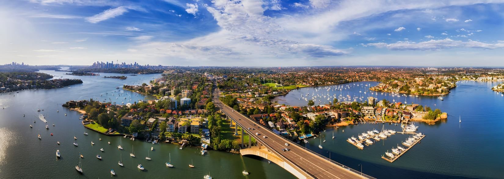 An Aerial View of a Bridge Over a Body of Water Surrounded by Boats — Accurate Fitout Solutions In Parramatta, NSW