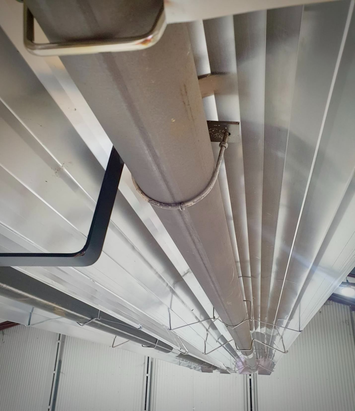 A Bunch of Pipes Hanging From the Ceiling of a Building — Accurate Fitout Solutions In Auburn, NSW