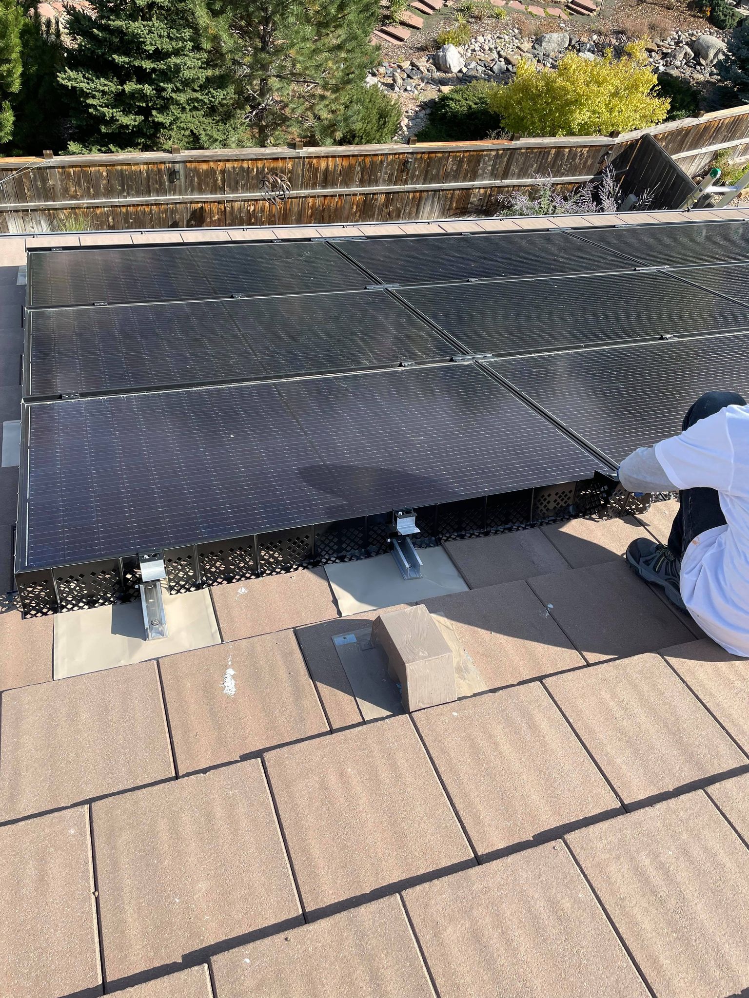 A man is installing solar panels on a roof.