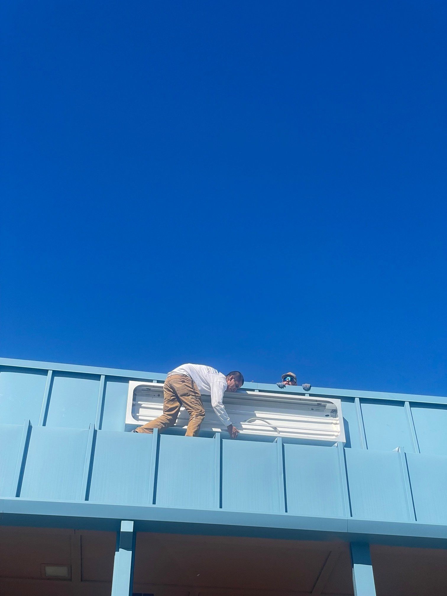 A man is standing on the roof of a building.