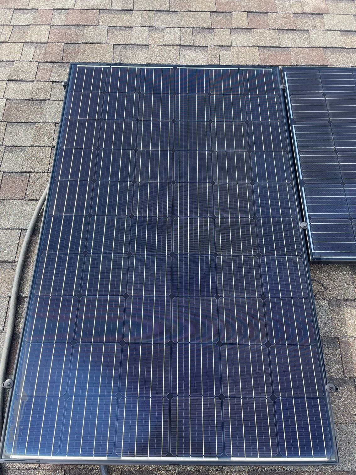 A solar panel is sitting on top of a brick roof.