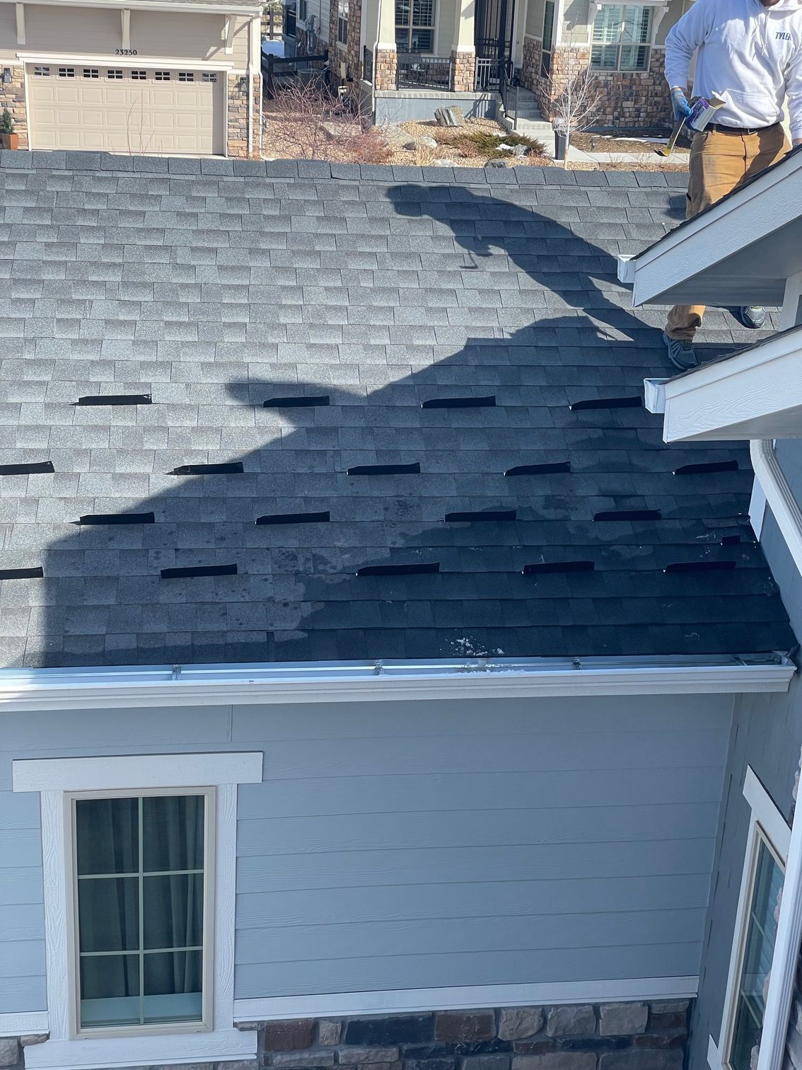 A man is standing on the roof of a house.