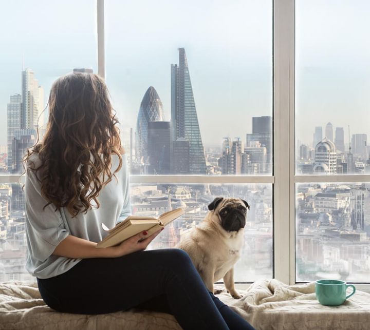 Woman with dog sitting next to the window
