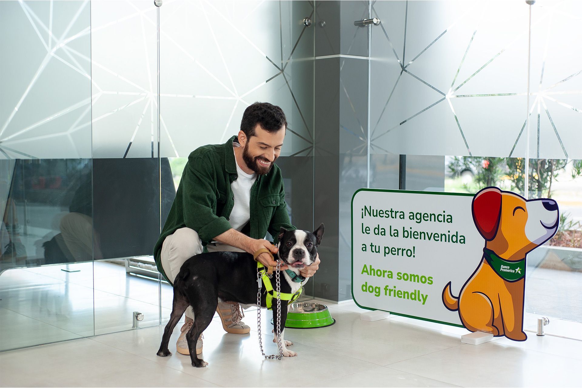 un hombre acaricia a un perro frente a un cartel que dice : ahora somos dog friendly