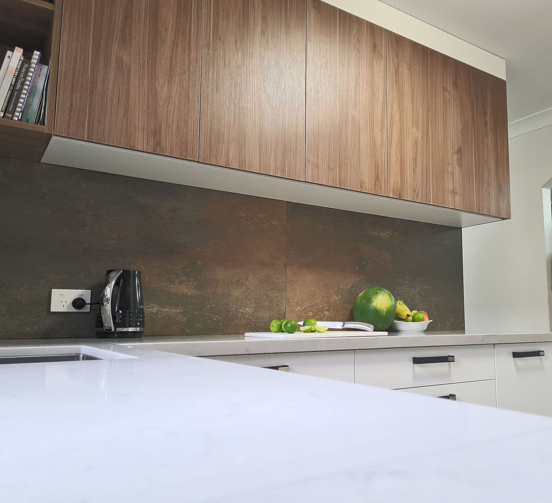 Wooden kitchen cabinets above a white bench top — The Right Kitchen Company In Berkeley, NSW