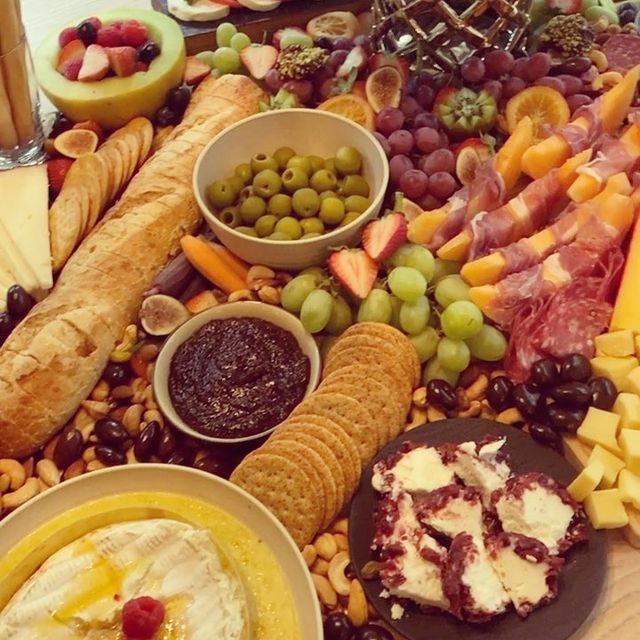 A table topped with a variety of food including crackers and fruit