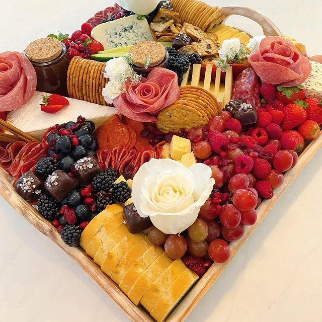 A wooden tray filled with fruits and bread