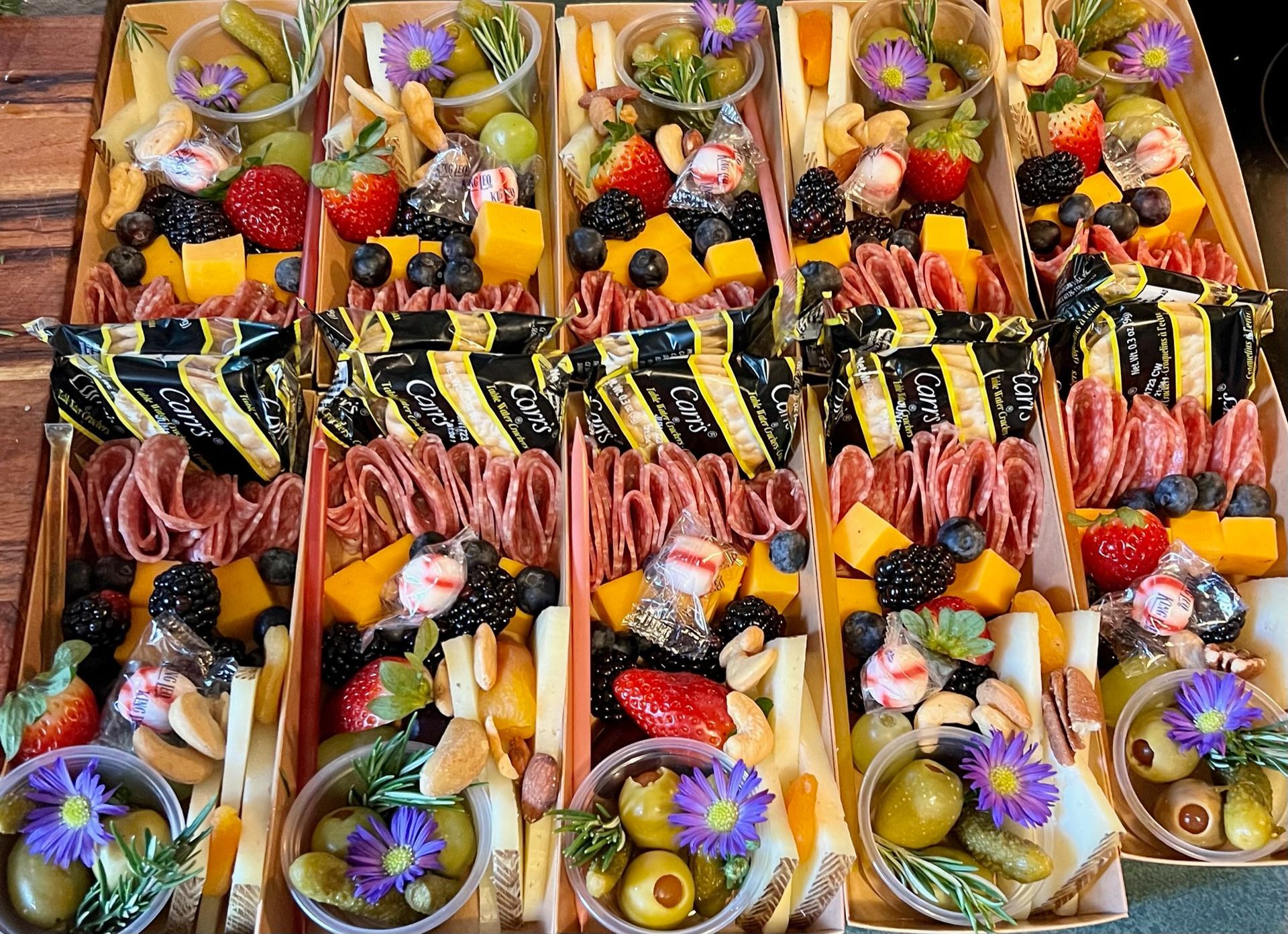 A wooden table topped charcuterie boxes