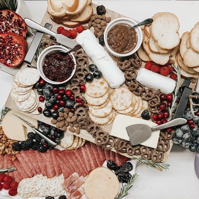 A table topped with a variety of food including crackers and berries