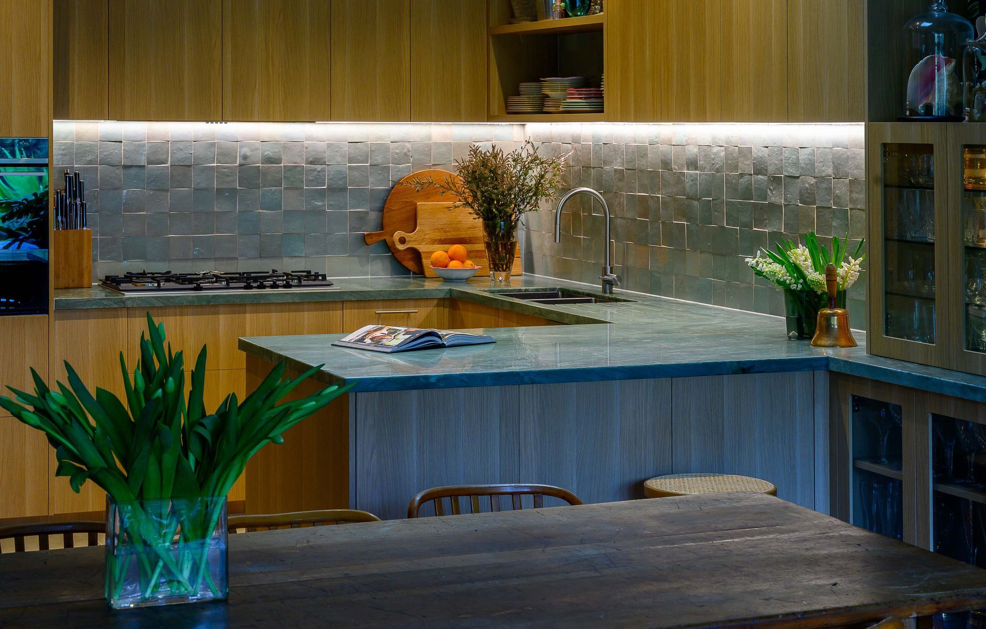 A kitchen with a table and chairs and a plant on the counter.