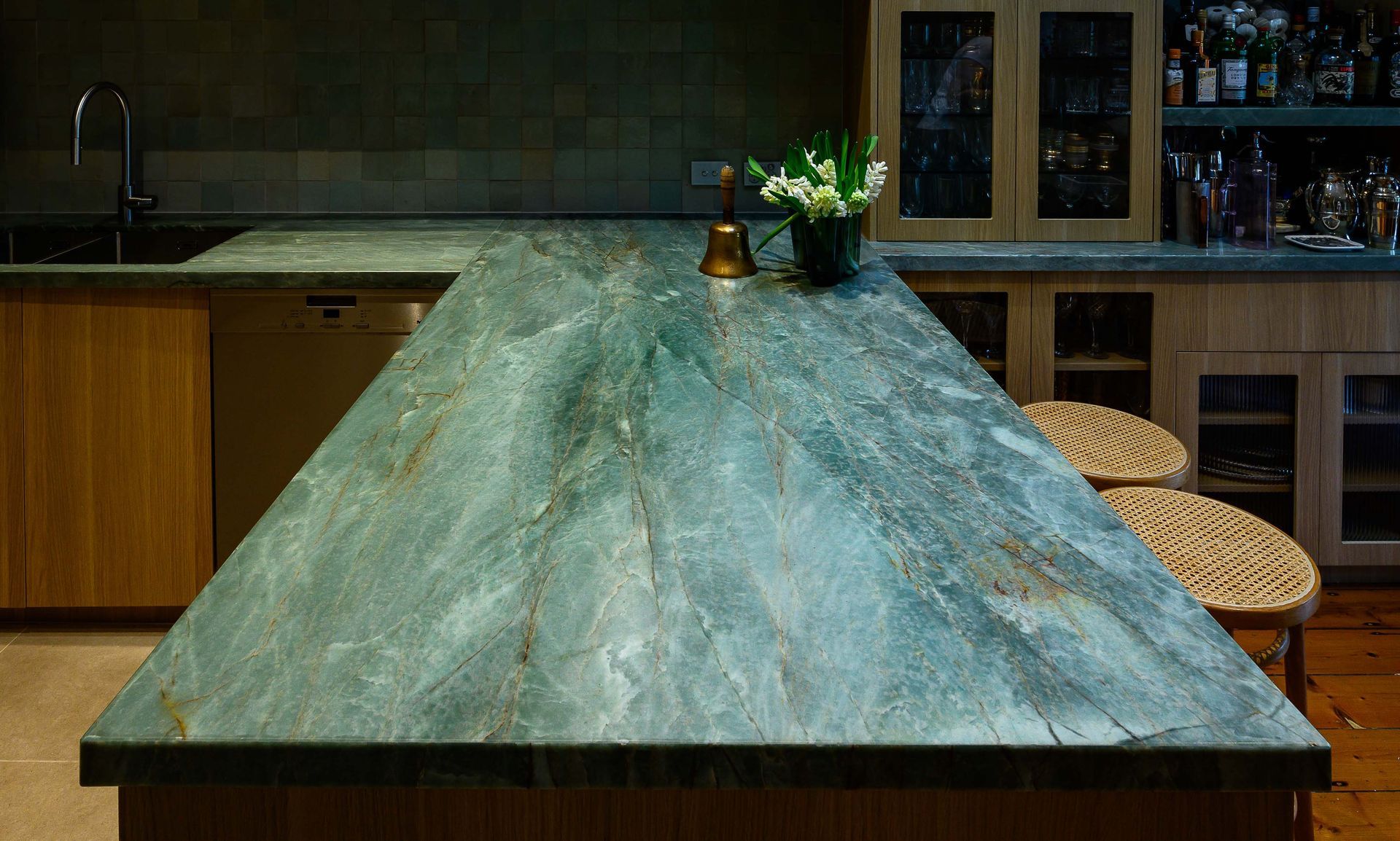 A kitchen with a green counter top and wooden cabinets.