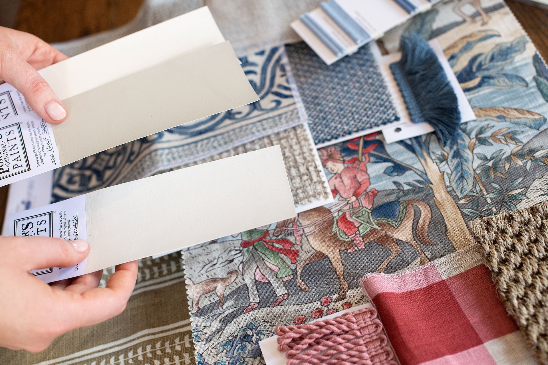 A living room with a table, lamp, vases and a painting on the wall.