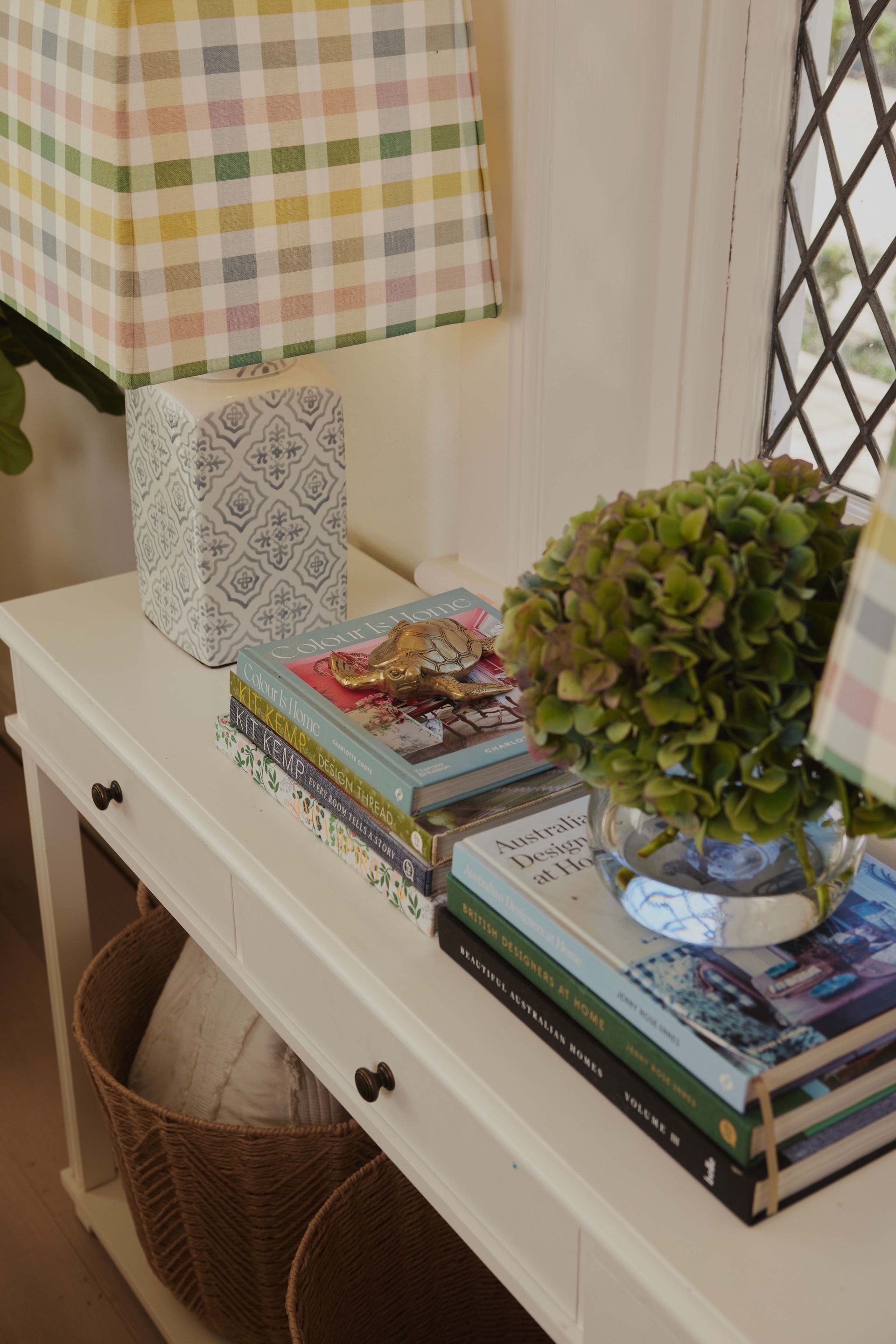 A table with a stack of books and a lamp on it.