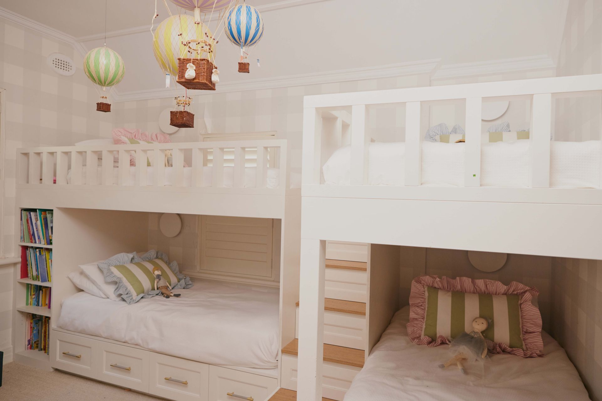 A bedroom with two bunk beds and hot air balloons hanging from the ceiling.