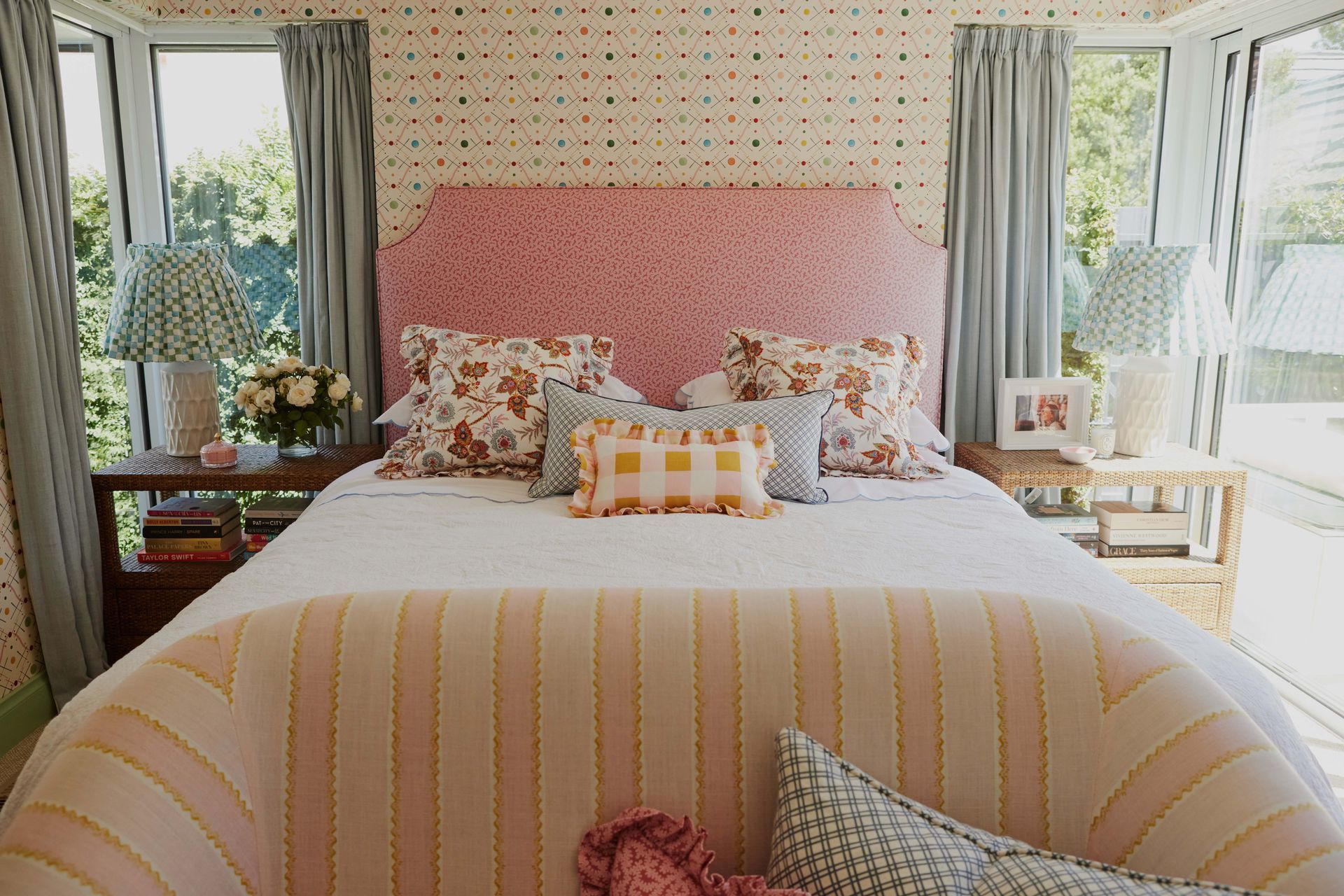 A bedroom with a bed and a chair with a pink headboard