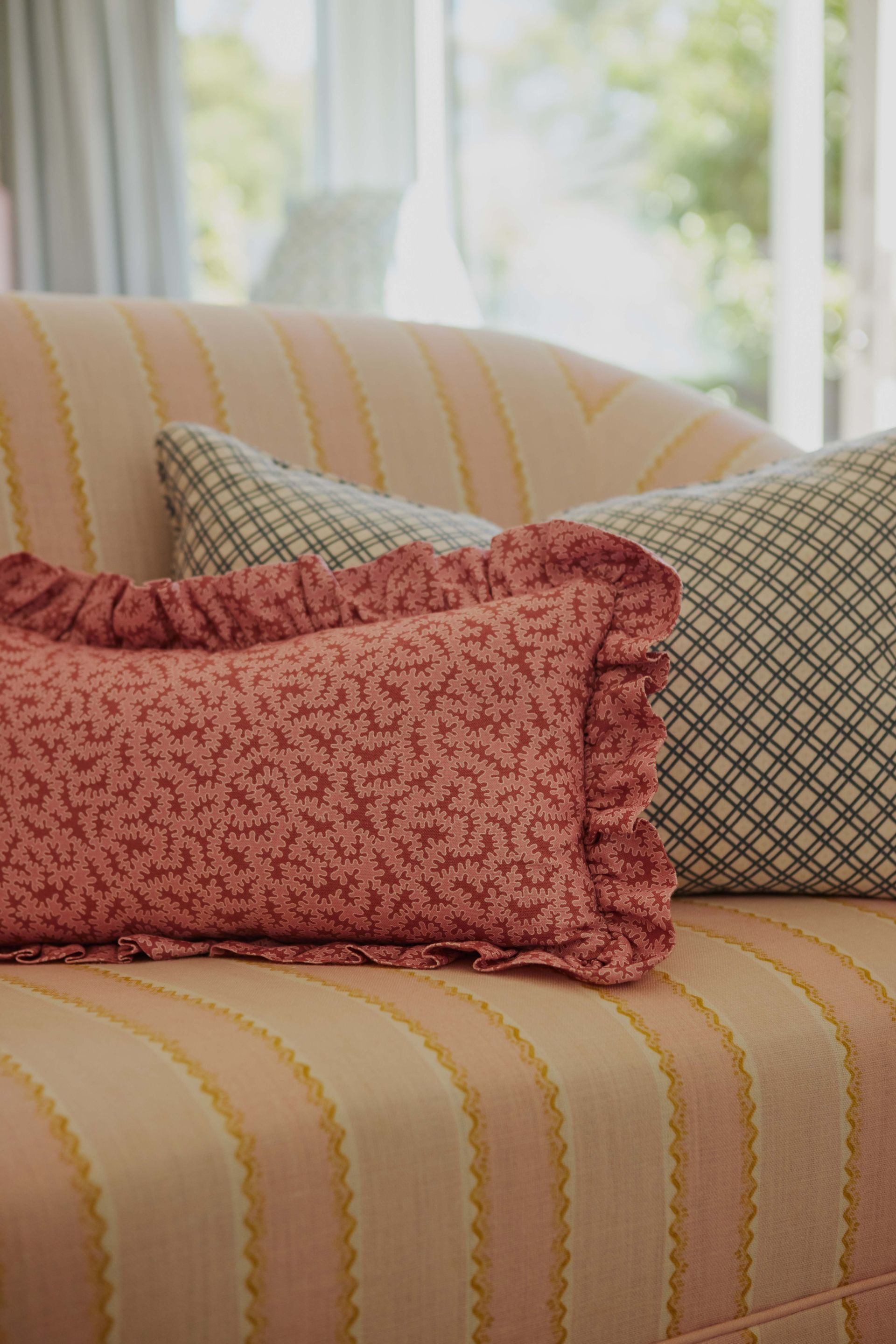 Two pillows are sitting on a striped couch in a living room.