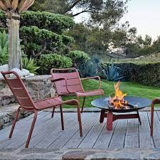 A patio with chairs, a table and a fire pit.