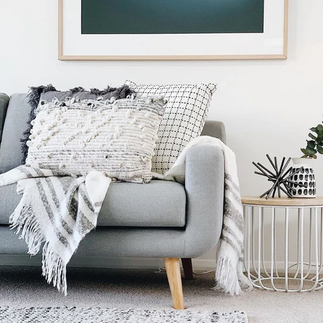 A living room with a couch, table, and a picture on the wall.