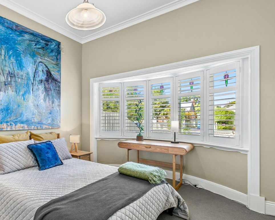 There is a large painting on the wall above the bed in the bedroom.