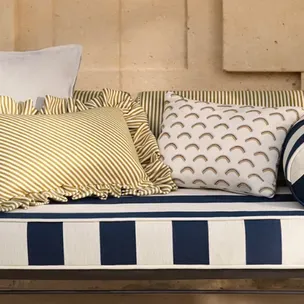 A blue and white striped couch with pillows on it