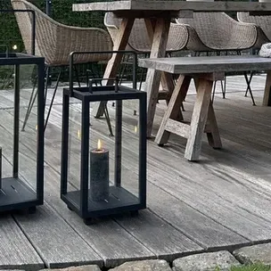 A wooden deck with a table and chairs and lanterns on it.