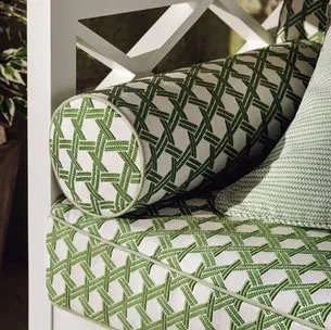 A white chair with green and white pillows on it