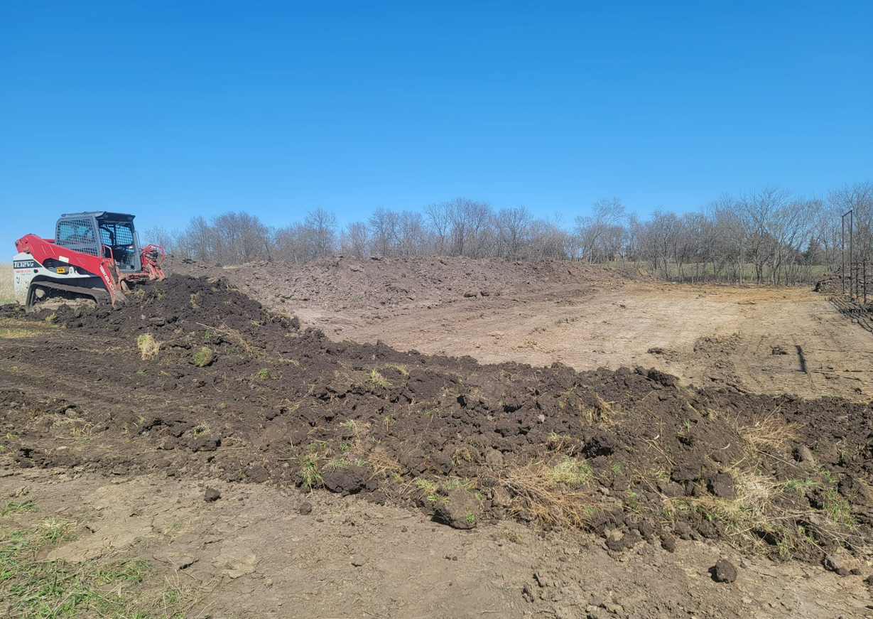 A bulldozer is moving dirt in a field.
