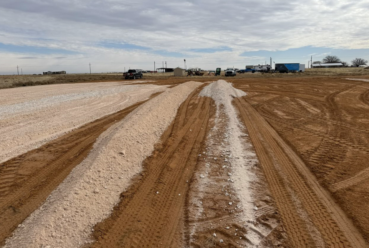 A dirt road with a lot of tire tracks on it.